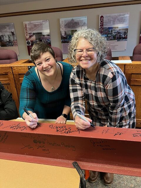 Director and Asst Director signing last beam for expansion
